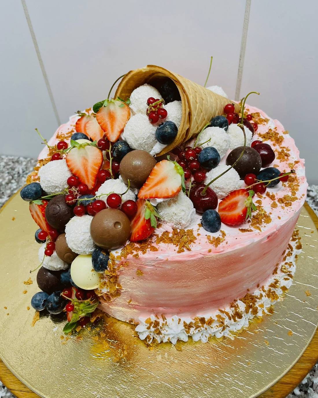 Bogyós gyümölcsökkel és ostyatölcsérrel díszített torta