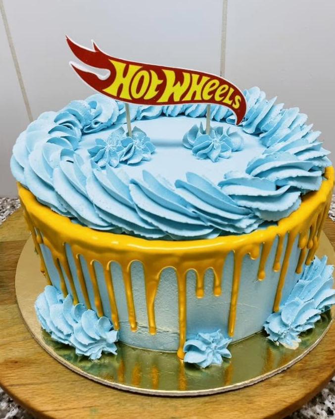 Világoskék torta arany csorgatással és autós zászló-dísszel